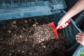 une pelle pioche dans un bac à compost