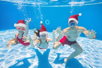 Enfants avec des bonnets de Noël dans la piscine
